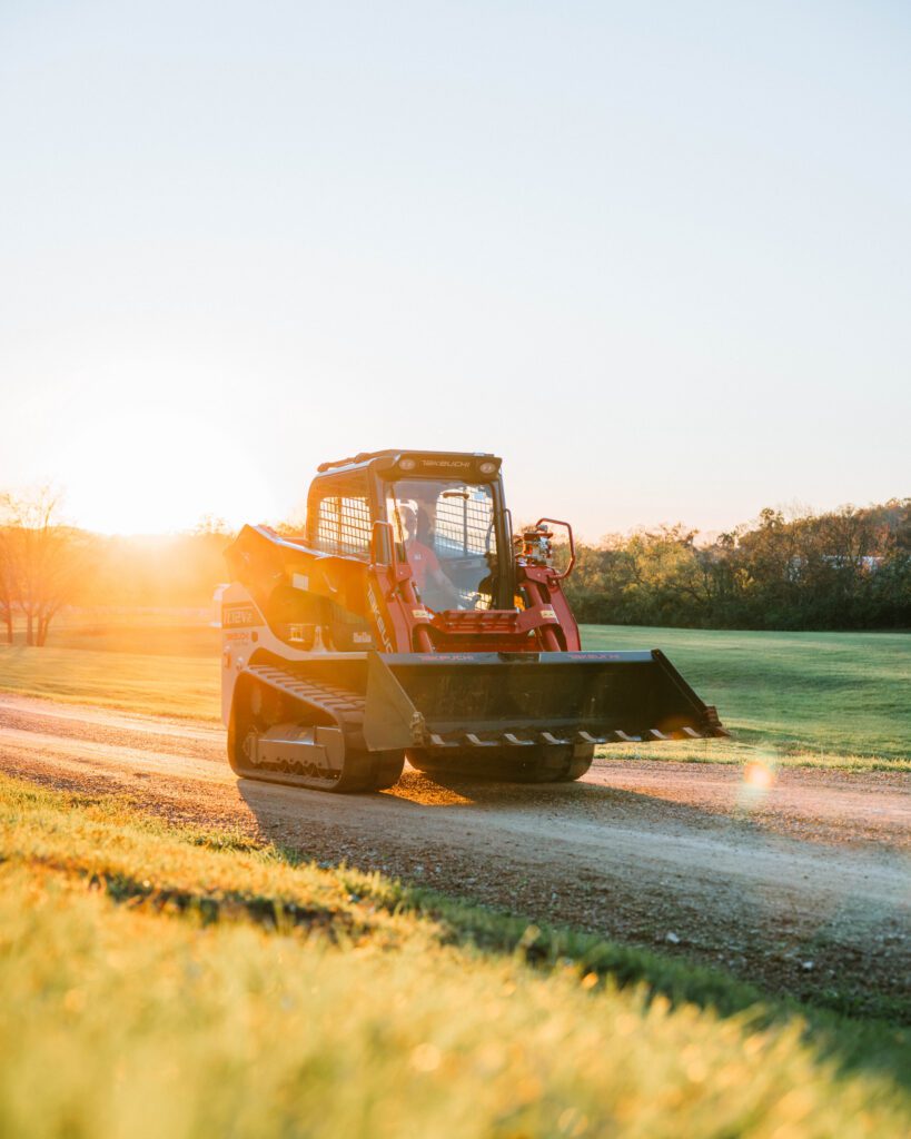 Takeuchi TL12V2 rijdend met de ondergaande zon