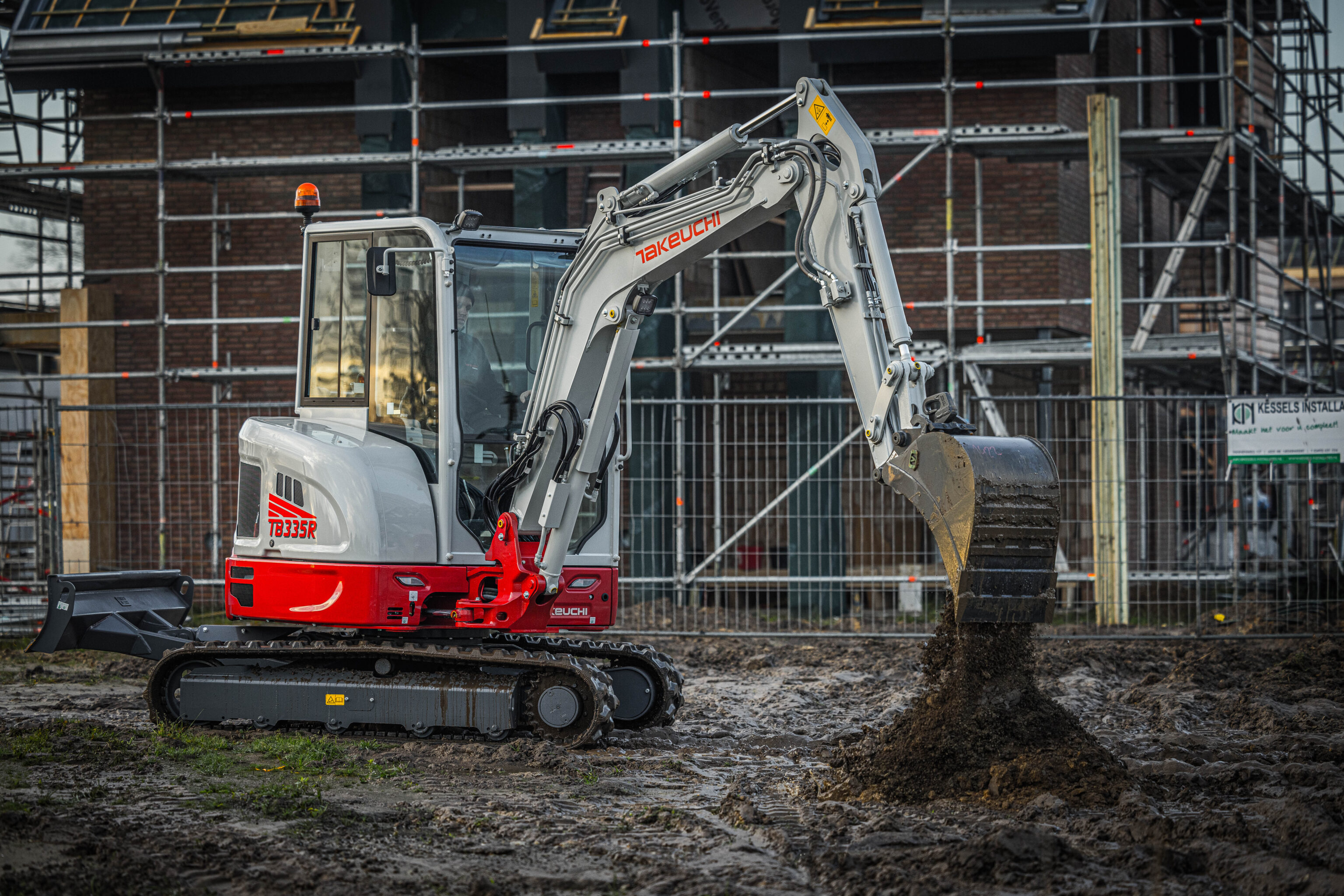 Takeuchi TB335R graafmachine aan het werk bij een nieuwbouwhuis