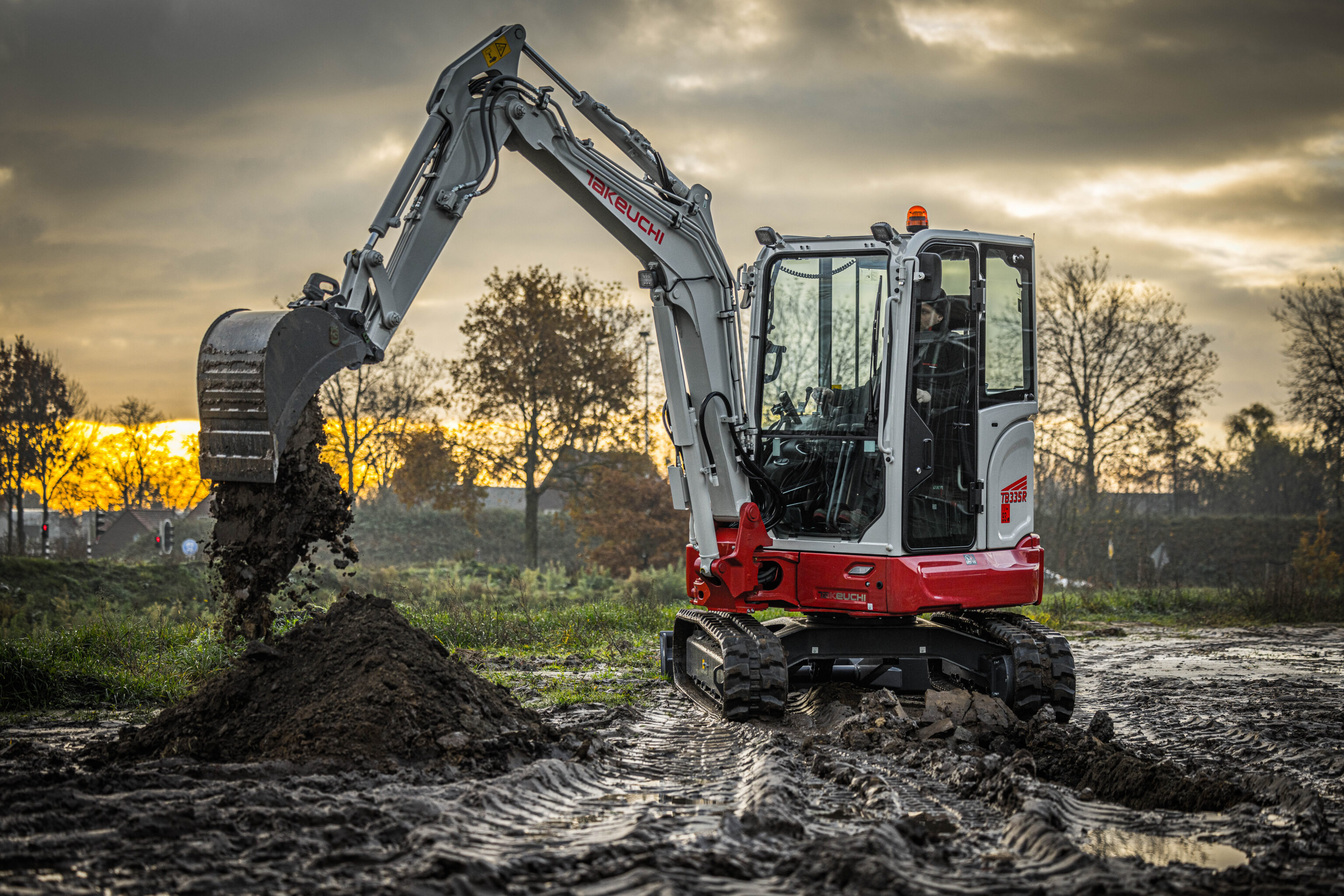Takeuchi TB335R graafmachine aan het werk met een smalle graafbak
