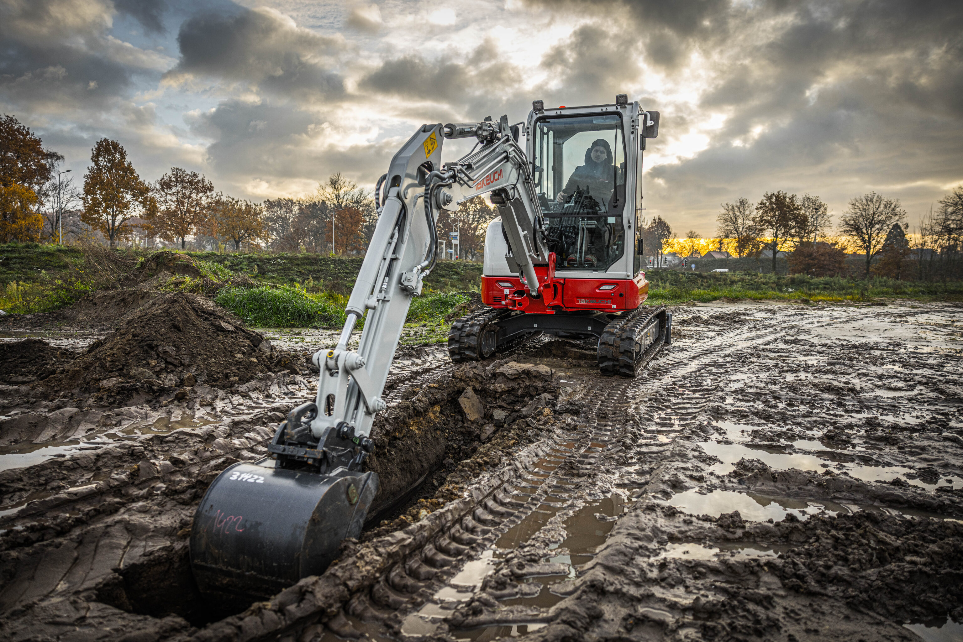 Takeuchi TB335R graafmachine graaft een sleuf