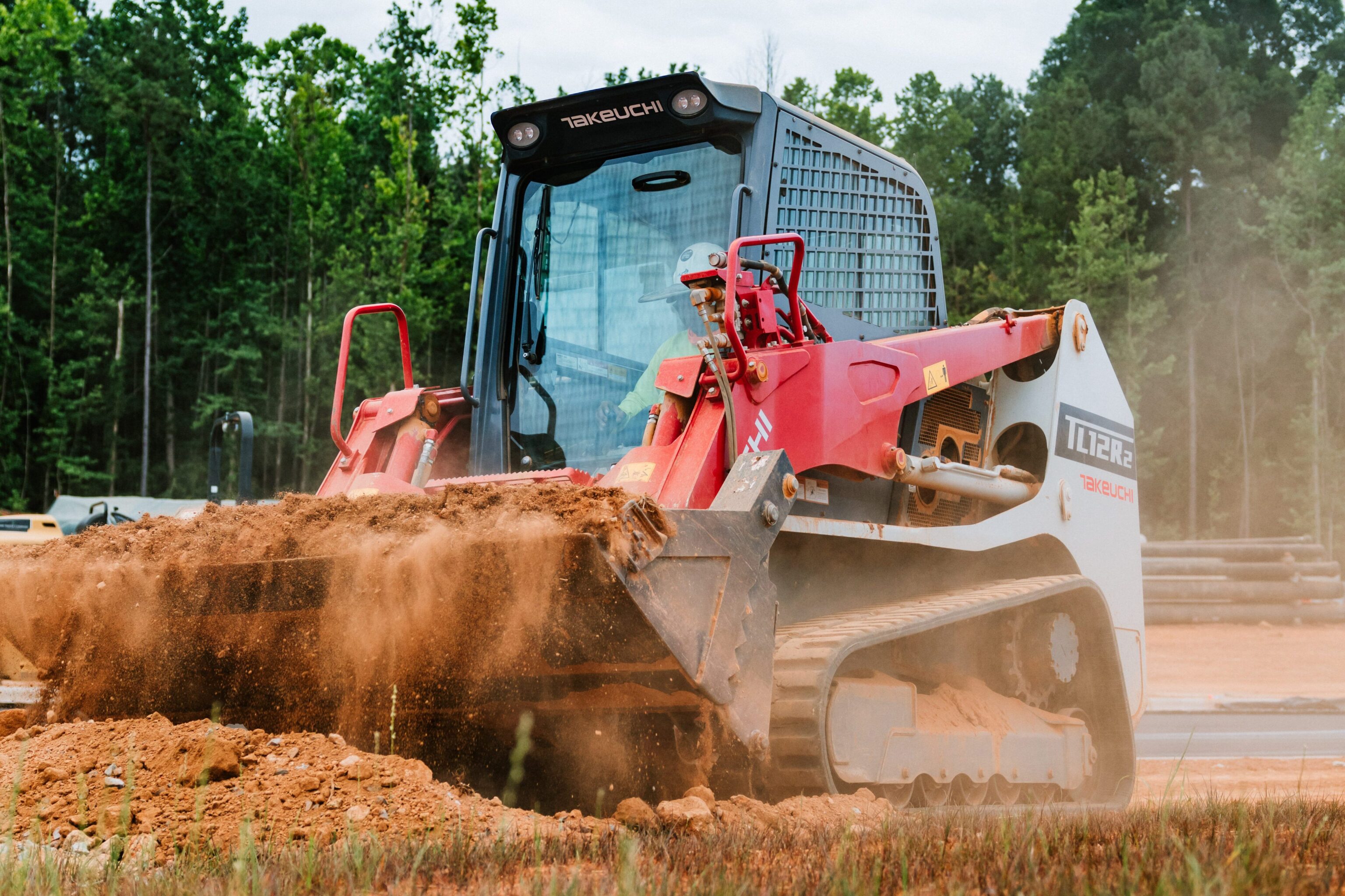 Takeuchi TL12R2 schranklader duwt zand weg