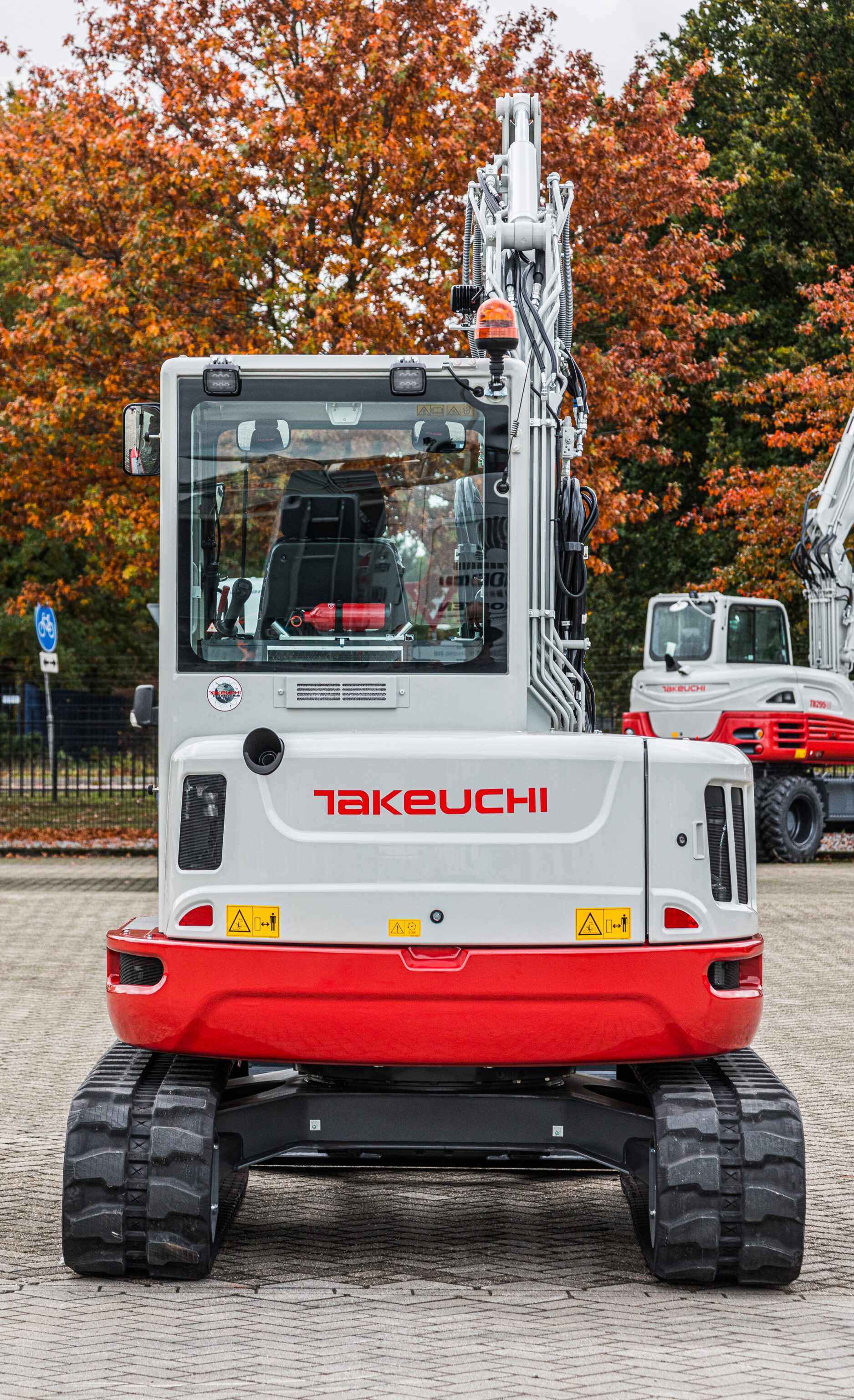 Pelle Takeuchi TB257FR vue de dos, avec des arbres en arrière-plan