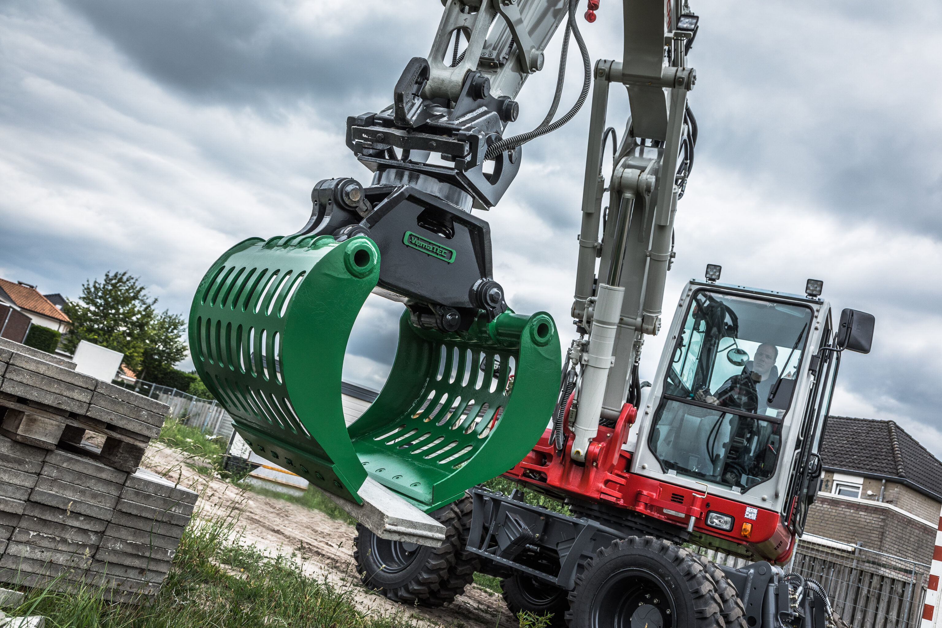 Takeuchi graafmachine klemt een opsluitband met een sorteergrijper
