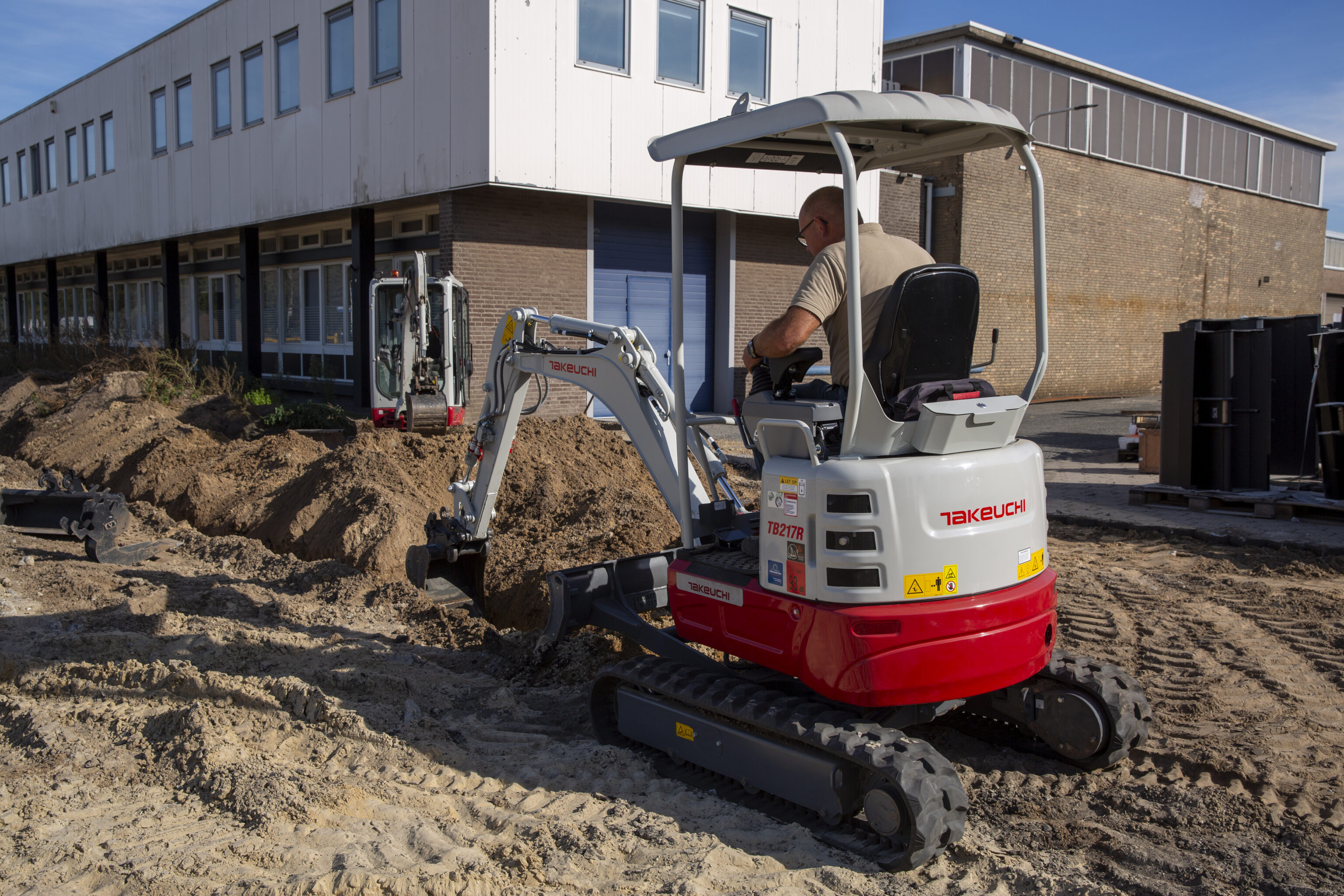 Takeuchi TB217R graaft gat bij gebouw
